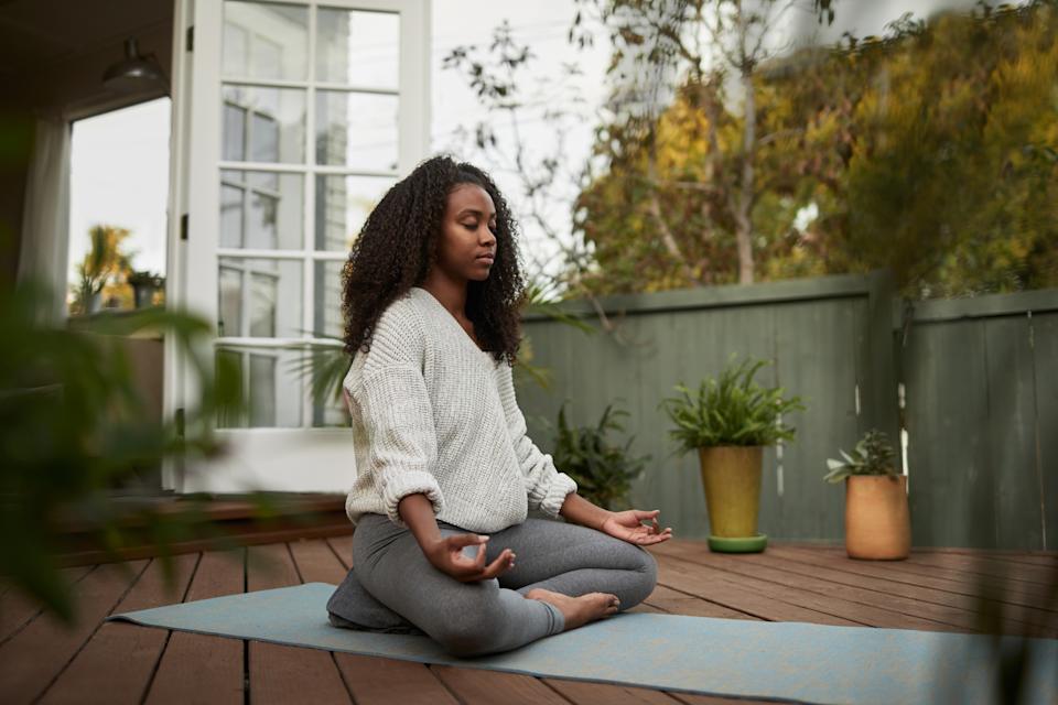 Woman practicing mindfulness meditation with eyes closed in a calm space.