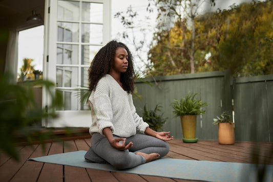 Woman practicing mindfulness meditation with eyes closed in a calm space.