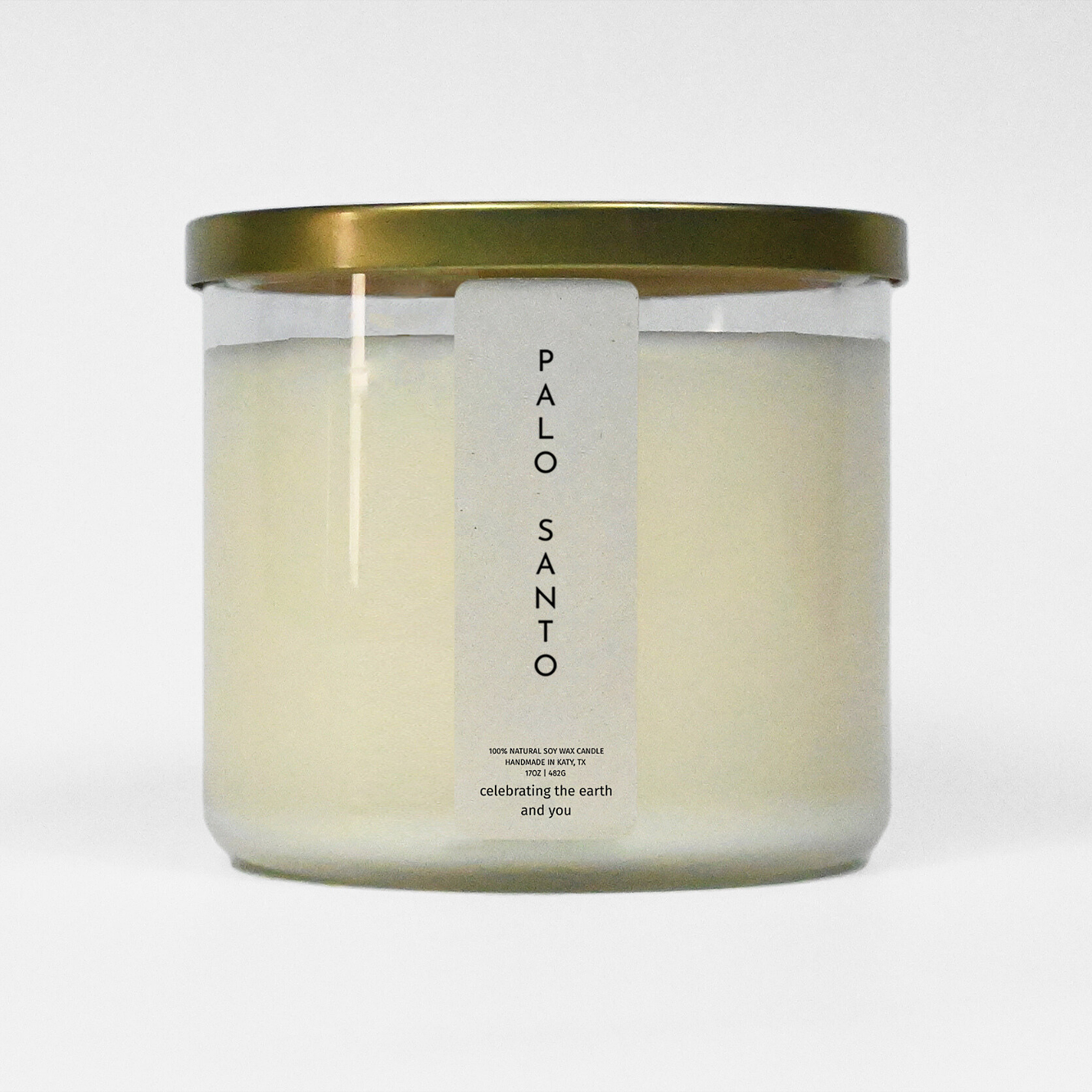 Candle in a glass jar with a gold lid on a white background