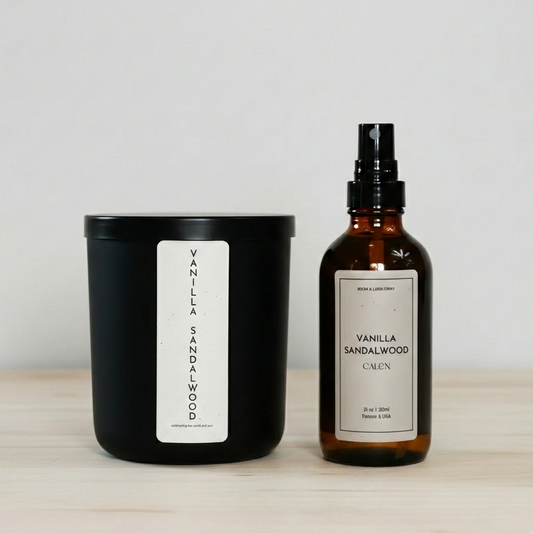 Vanilla sandalwood candle and bottle on a wooden surface with a white background